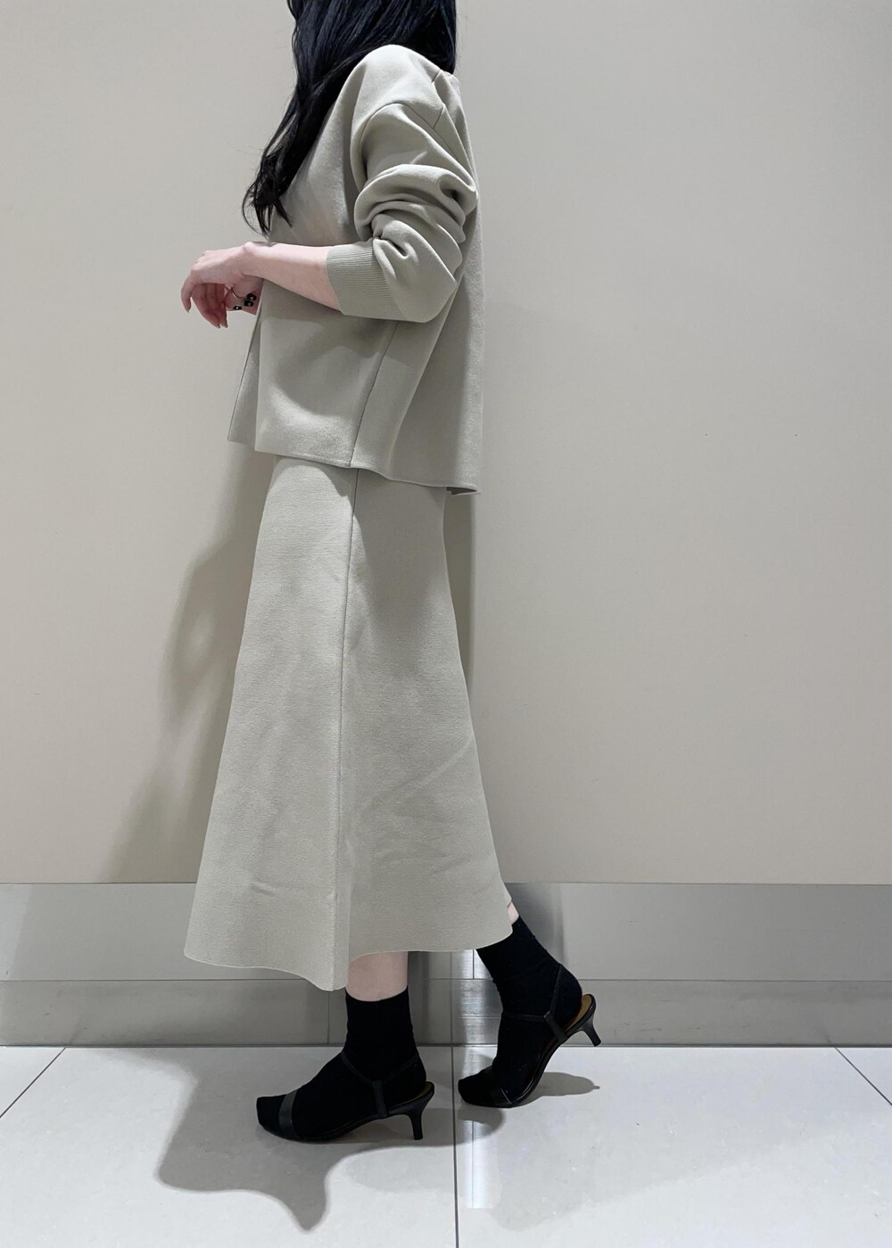 ブラウン系のショルダーバッグ、ベージュ系のスカート、ベージュ系のニット/セーターを着用したレディースの冬コーディネートの5枚目の写真