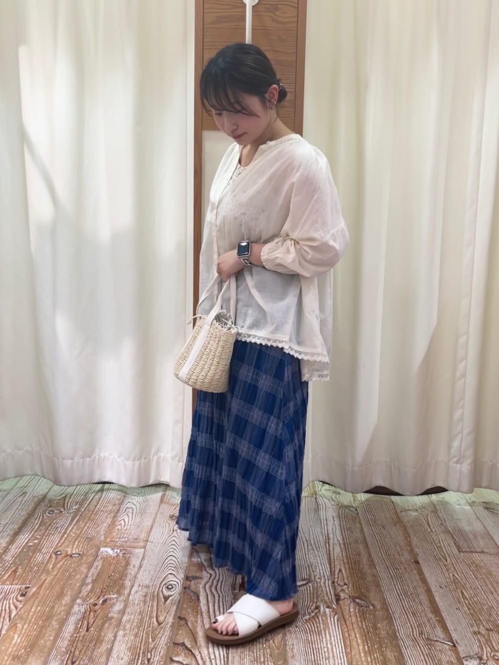 イエロー系のタンクトップ、ホワイト系のシャツ/ブラウス、ブルー系のスカートを着用したレディースの夏コーディネートの2枚目の写真