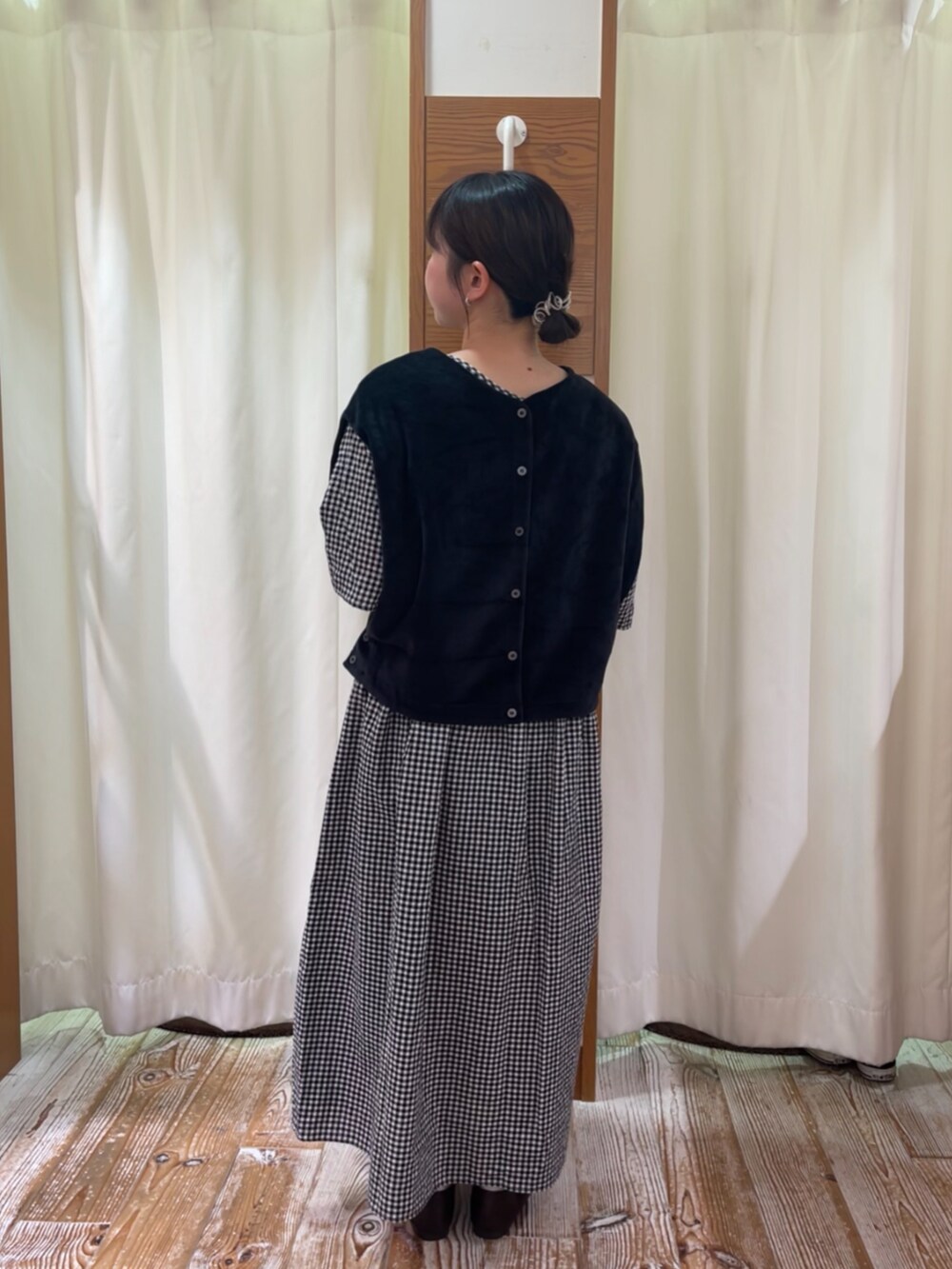 ブラック系のワンピース、ブラック系のドレスシューズ、ブラック系のベストを着用したレディースの秋コーディネートの2枚目の写真