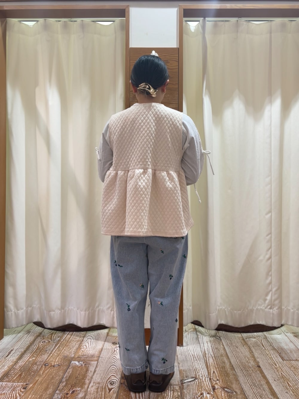 ブルー系のデニムパンツ、ホワイト系のベスト、ホワイト系のシャツ/ブラウスを着用したレディースの冬コーディネートの2枚目の写真