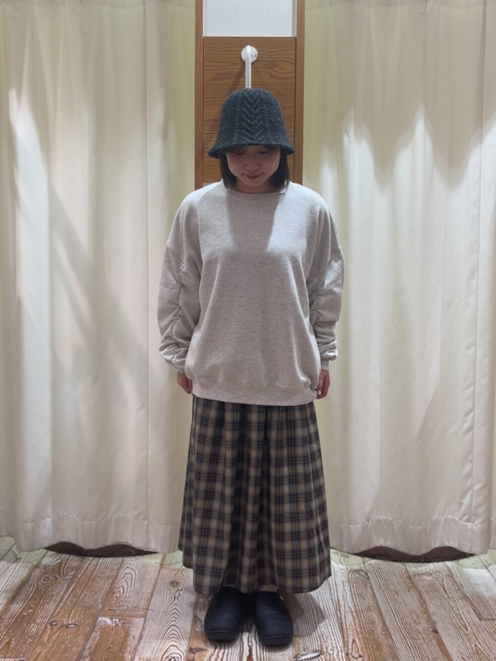 ホワイト系のTシャツ/カットソー、ブルー系のスカート、グレー系のハットを着用したレディースの冬コーディネートの2枚目の写真