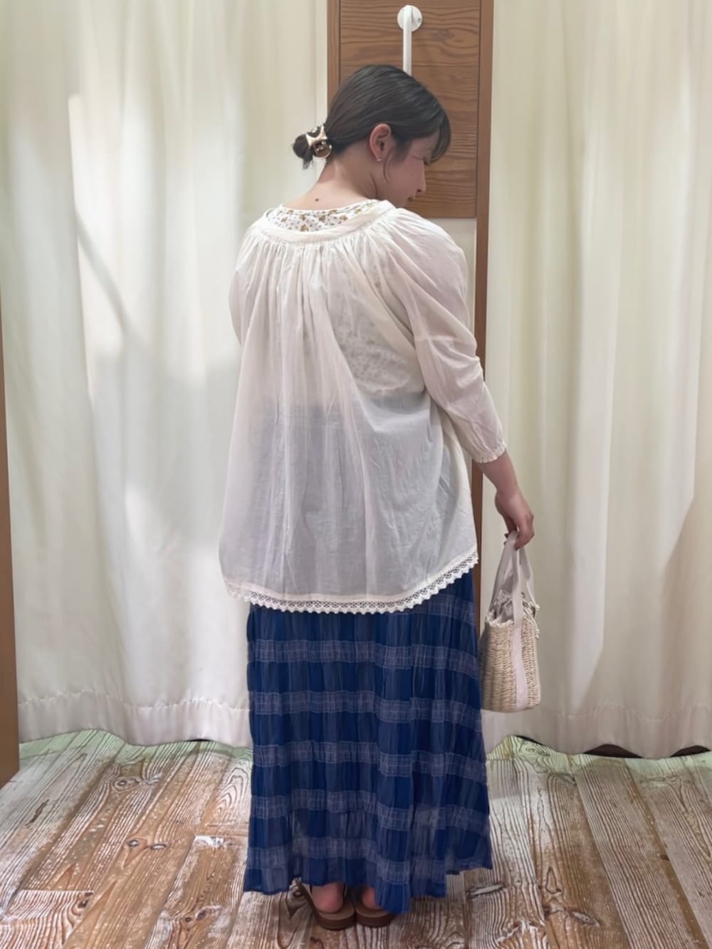 イエロー系のタンクトップ、ホワイト系のシャツ/ブラウス、ブルー系のスカートを着用したレディースの夏コーディネートの3枚目の写真