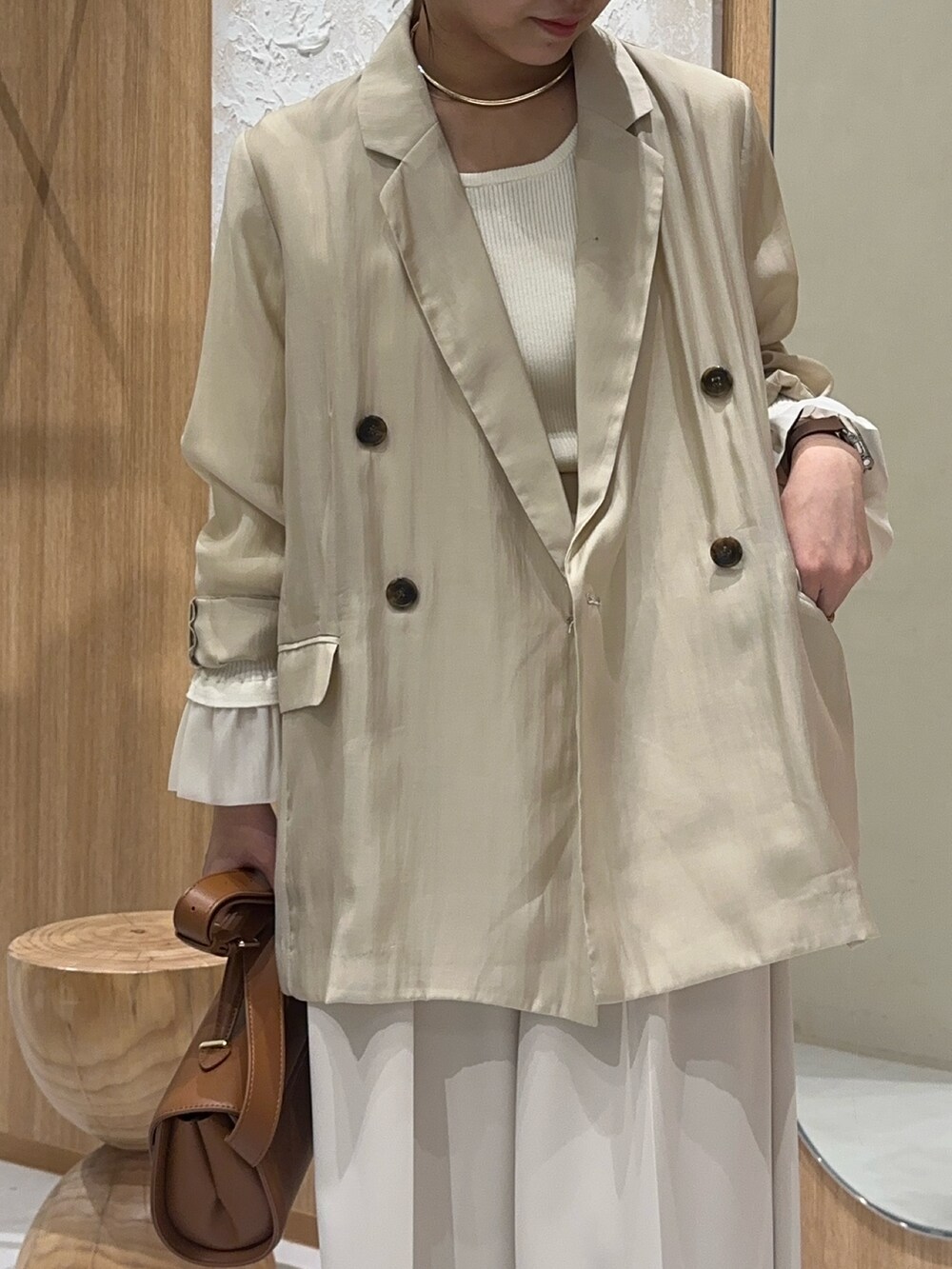 ベージュ系のテーラードジャケット、ホワイト系のニット/セーター、ホワイト系のその他パンツを着用したレディースの秋コーディネートの2枚目の写真