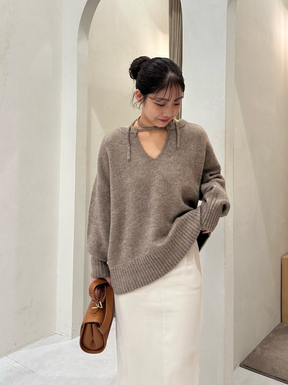 ブラウン系のニット/セーター、ホワイト系のスカート、ブラック系のパンプスを着用したレディースの秋コーディネートの4枚目の写真