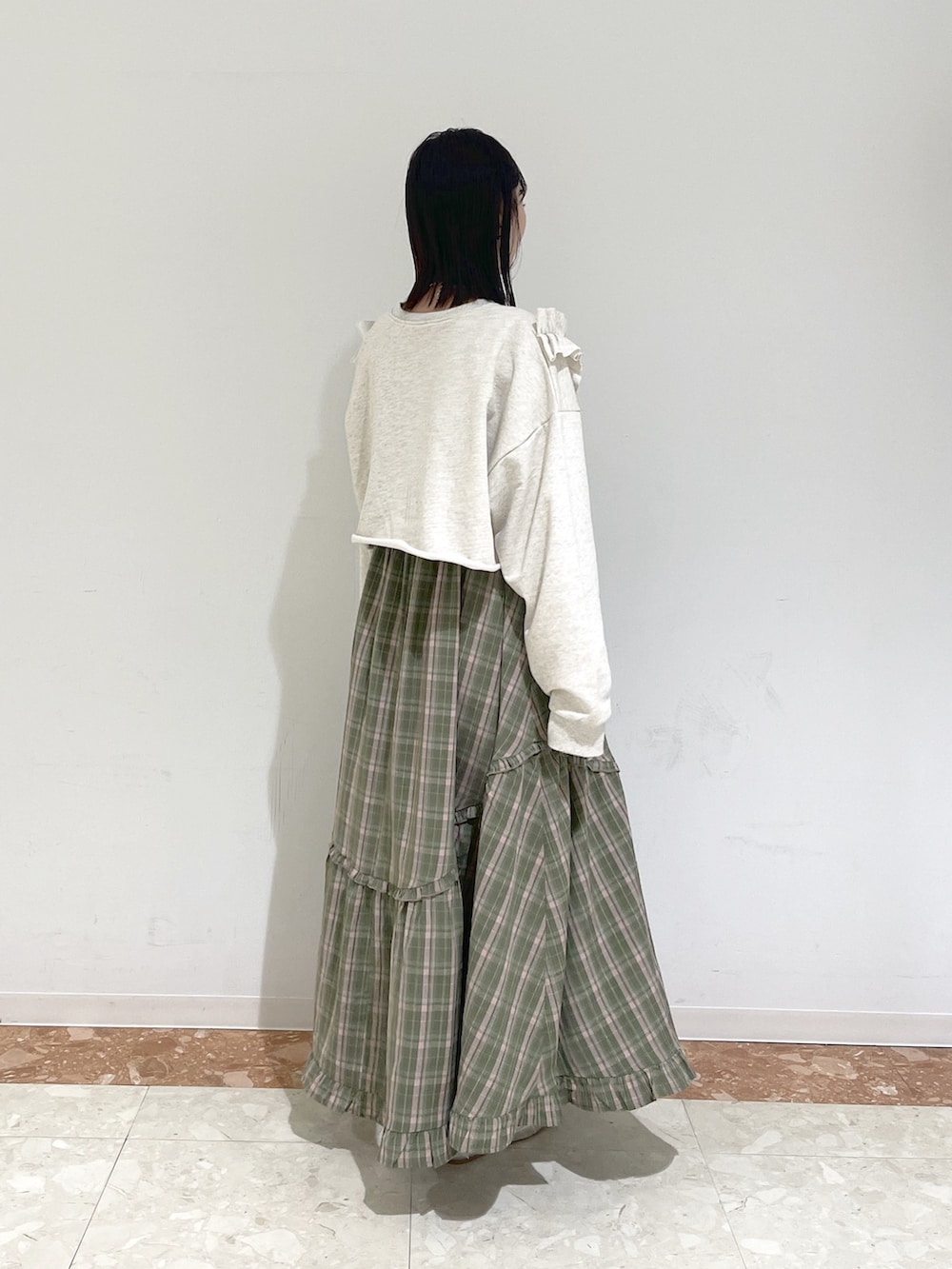 ホワイト系のTシャツ/カットソー、グリーン系のワンピース、シルバー系のスニーカーを着用したレディースの冬コーディネートの4枚目の写真