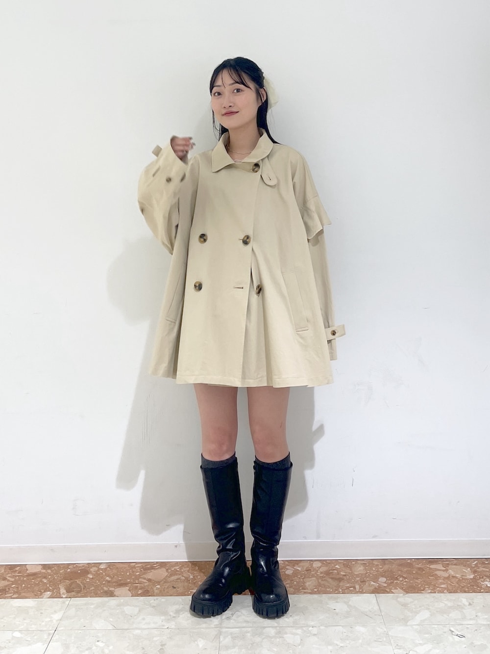 ピンク系のTシャツ/カットソー、ブラック系のワンピース、ベージュ系のトレンチコートを着用したレディースの春コーディネートの7枚目の写真