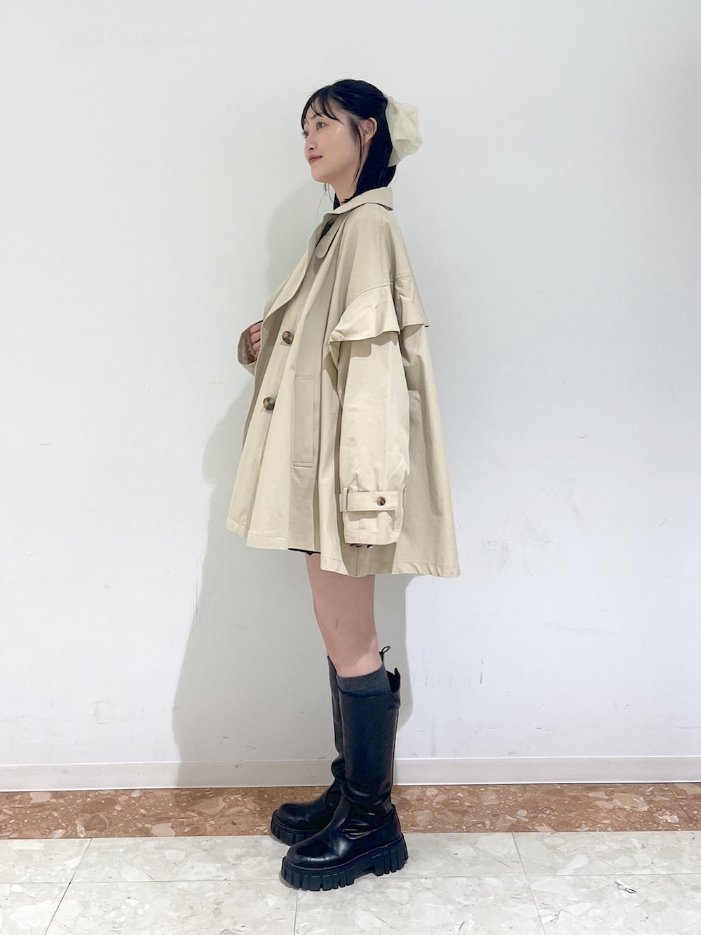 ピンク系のTシャツ/カットソー、ブラック系のワンピース、ベージュ系のトレンチコートを着用したレディースの春コーディネートの3枚目の写真