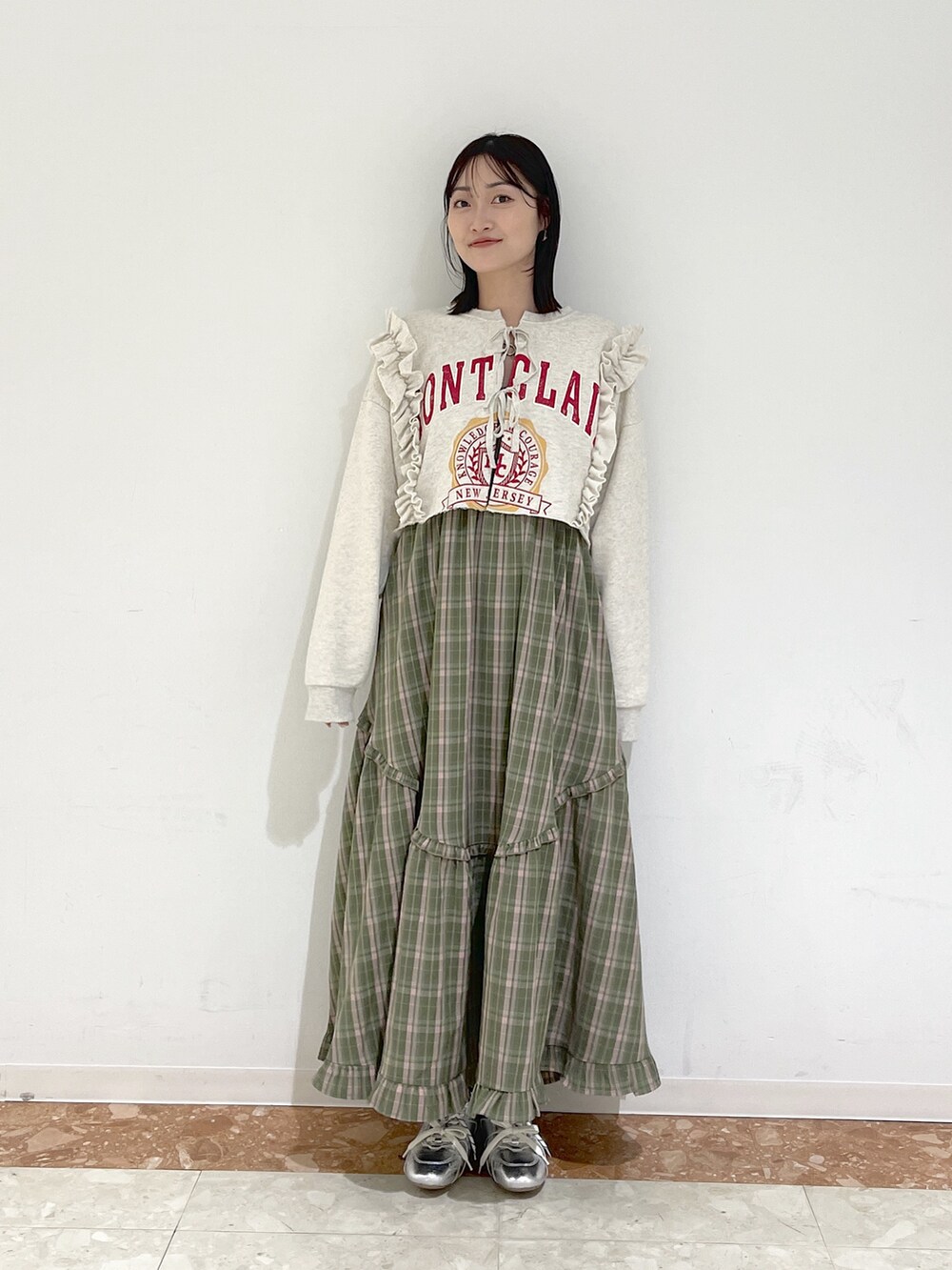 ホワイト系のTシャツ/カットソー、グリーン系のワンピース、シルバー系のスニーカーを着用したレディースの冬コーディネートの2枚目の写真