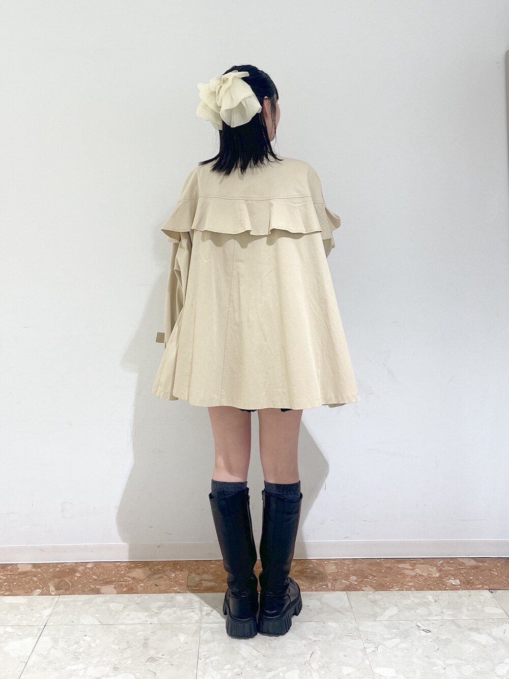 ピンク系のTシャツ/カットソー、ブラック系のワンピース、ベージュ系のトレンチコートを着用したレディースの春コーディネートの9枚目の写真