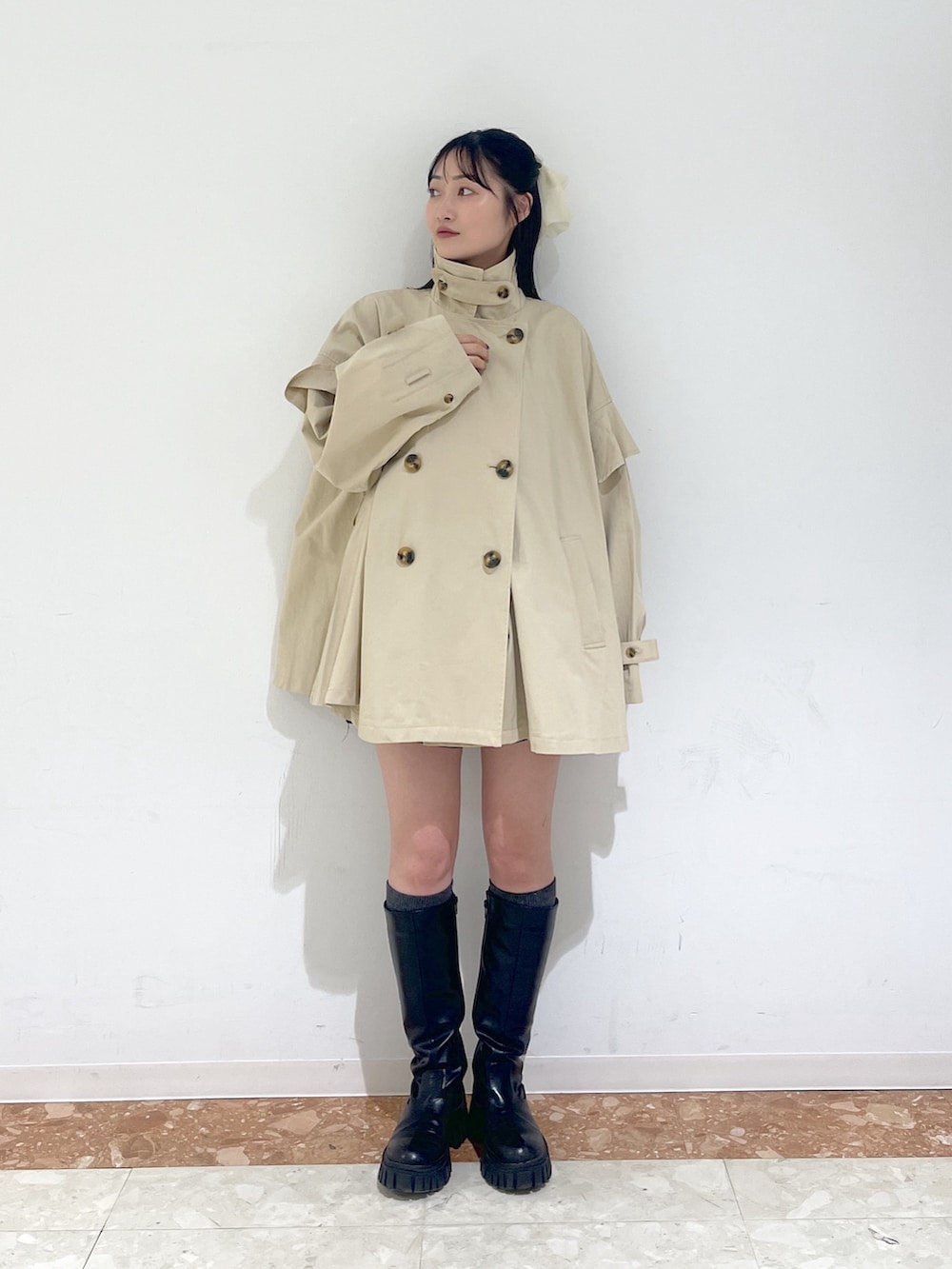 ピンク系のTシャツ/カットソー、ブラック系のワンピース、ベージュ系のトレンチコートを着用したレディースの春コーディネートの5枚目の写真