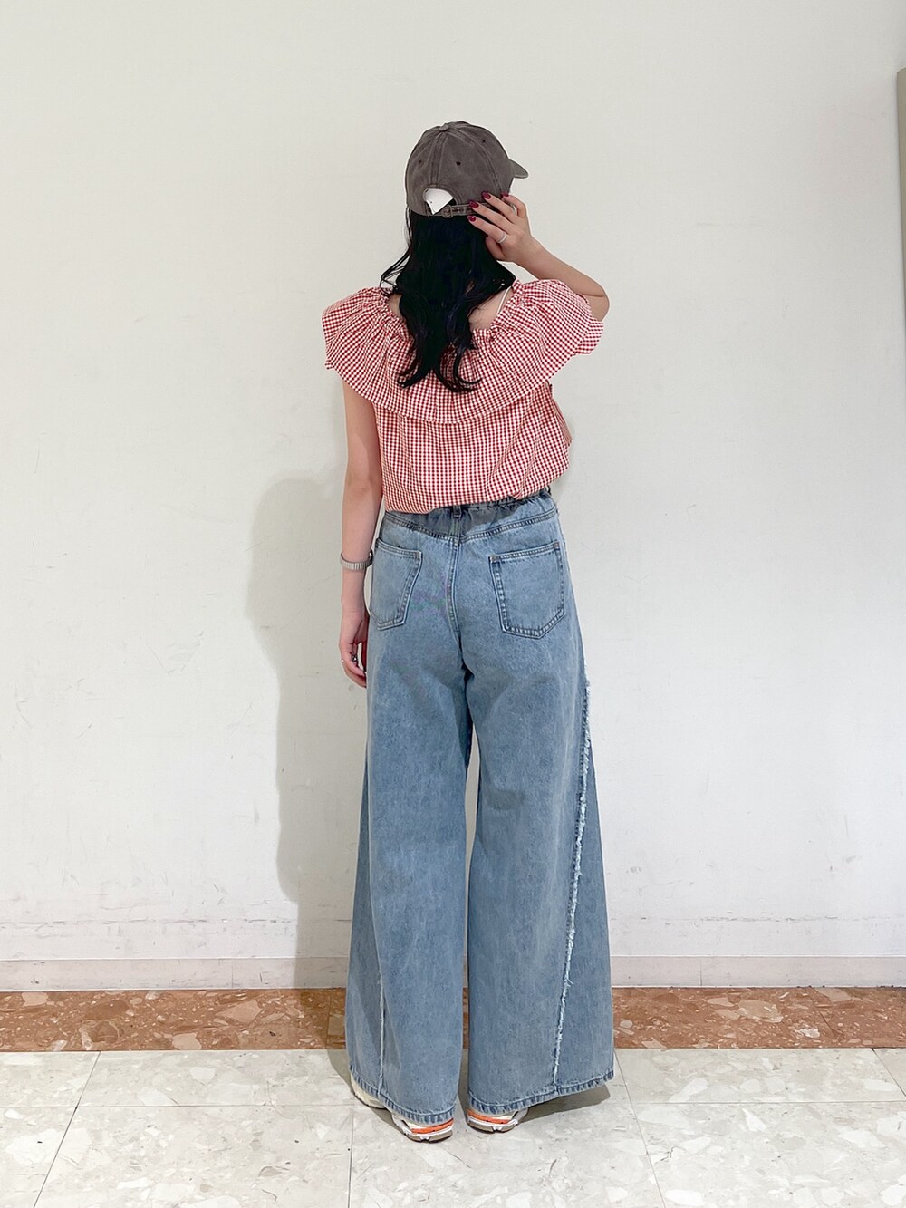 レッド系のシャツ/ブラウス、ブルー系のデニムパンツ、ブラウン系のキャップを着用したレディースの春コーディネートの4枚目の写真