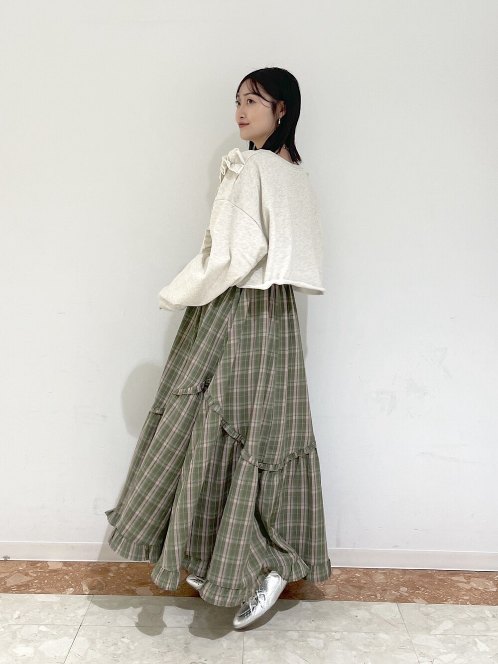 ホワイト系のTシャツ/カットソー、グリーン系のワンピース、シルバー系のスニーカーを着用したレディースの冬コーディネートの3枚目の写真