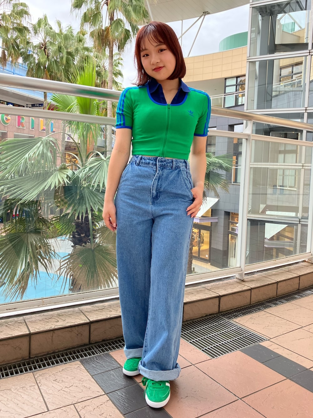 グリーン系のTシャツ/カットソー、ブルー系のポロシャツ、ブルー系のデニムパンツを着用したレディースの春コーディネートの4枚目の写真