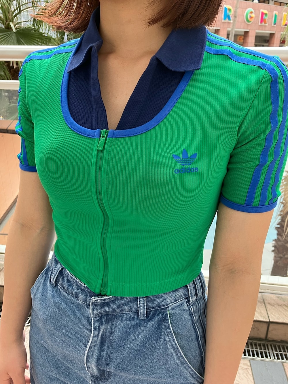 グリーン系のTシャツ/カットソー、ブルー系のポロシャツ、ブルー系のデニムパンツを着用したレディースの春コーディネートの5枚目の写真