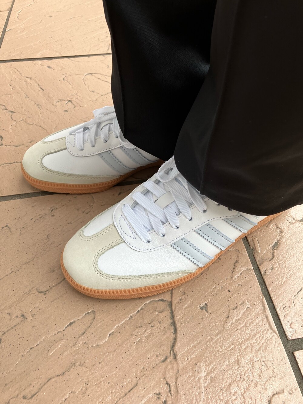 パープル系のトップス、ブラック系のスウェットパンツ、ホワイト系のスニーカーを着用したレディースの春コーディネートの5枚目の写真