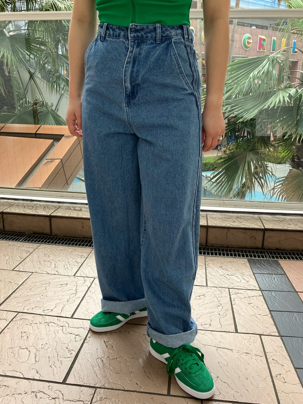 グリーン系のTシャツ/カットソー、ブルー系のポロシャツ、ブルー系のデニムパンツを着用したレディースの春コーディネートの2枚目の写真