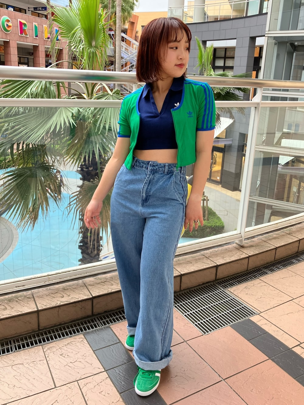 グリーン系のTシャツ/カットソー、ブルー系のポロシャツ、ブルー系のデニムパンツを着用したレディースの春コーディネートの3枚目の写真
