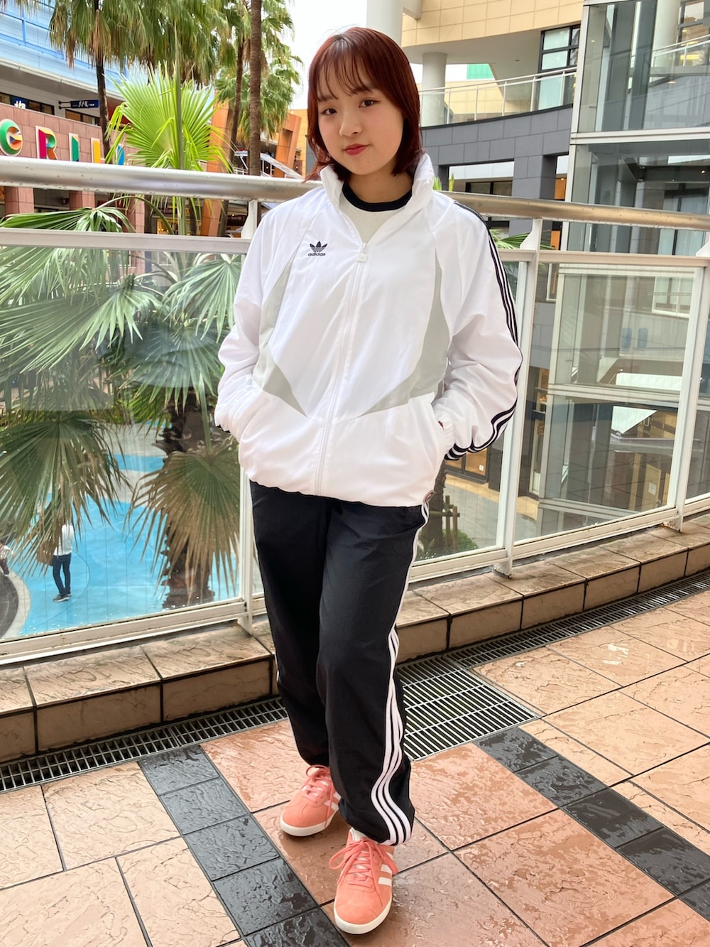 ホワイト系のパーカー、ブラック系のその他パンツ、レッド系のスニーカーを着用したレディースの春コーディネートの3枚目の写真