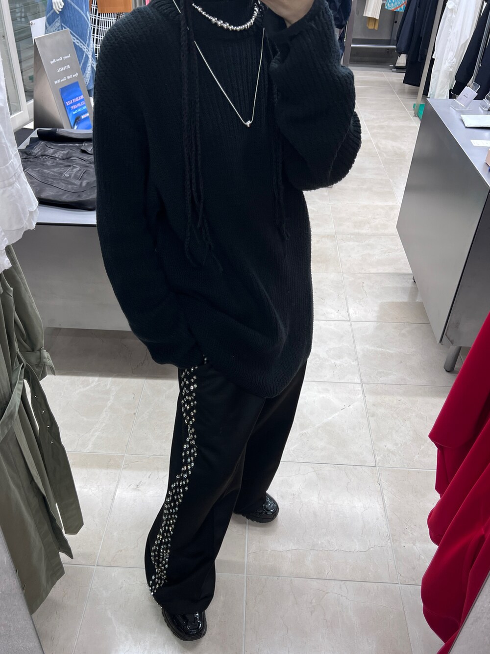 ブラック系のニット/セーター、ブラック系のスラックス、ブラック系のスニーカーを着用したレディースの冬コーディネートの2枚目の写真