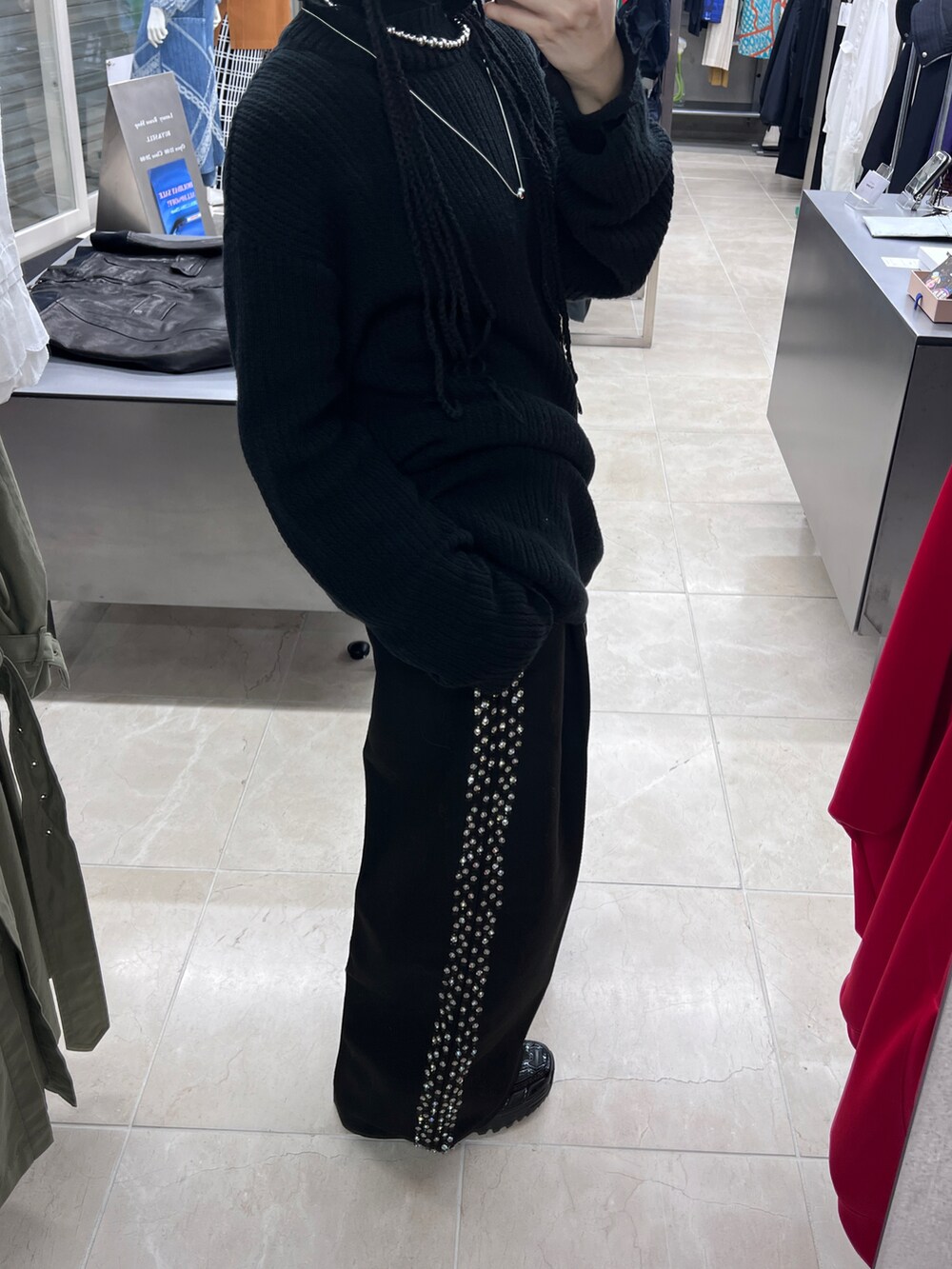 ブラック系のニット/セーター、ブラック系のスラックス、ブラック系のスニーカーを着用したレディースの冬コーディネートの3枚目の写真