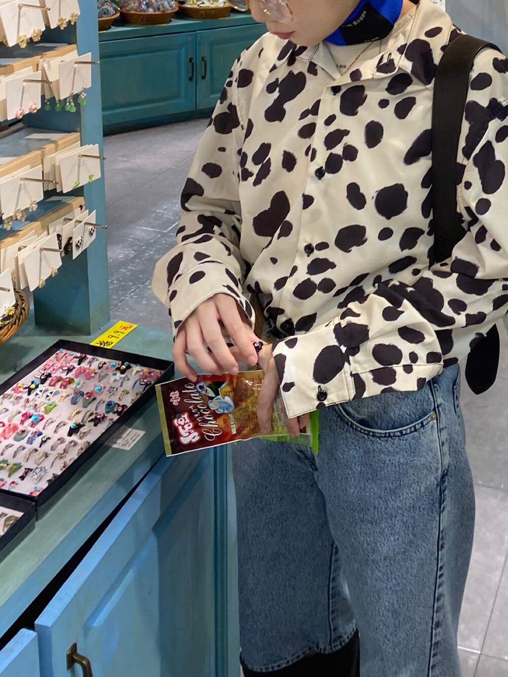 ベージュ系のシャツ/ブラウス、ブルー系のデニムパンツ、ブルー系のバッグを着用したレディースの秋コーディネートの2枚目の写真