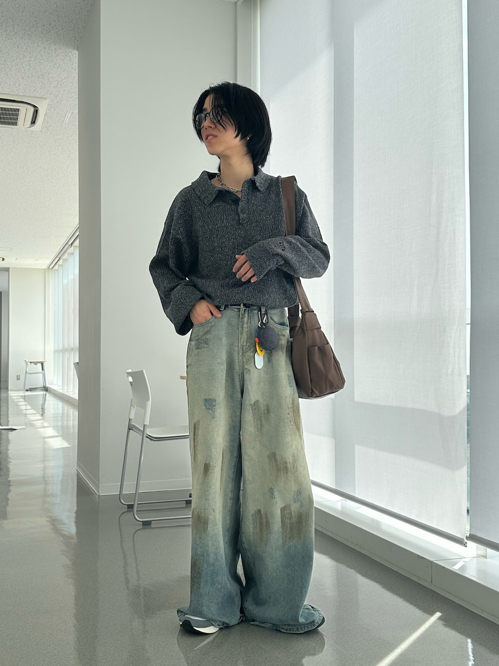 グレー系のニット/セーター、ブルー系のデニムパンツ、シルバー系のネックレスを着用したメンズの春コーディネートの3枚目の写真