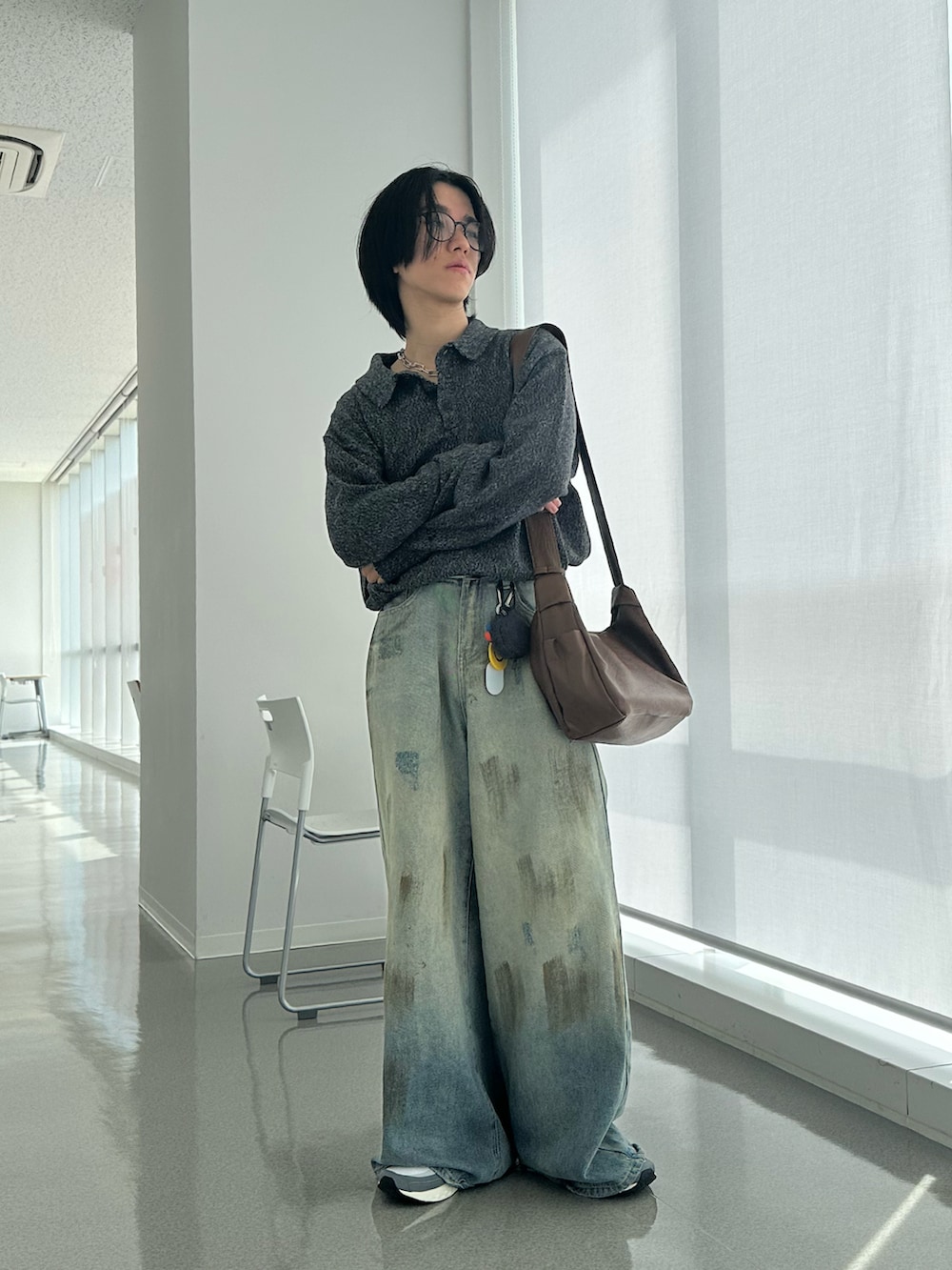 グレー系のニット/セーター、ブルー系のデニムパンツ、シルバー系のネックレスを着用したメンズの春コーディネートの2枚目の写真