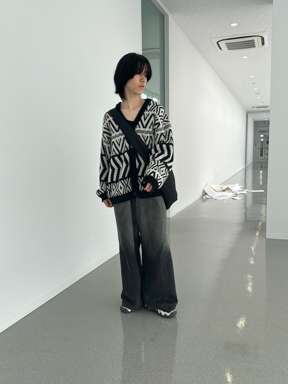 ブラック系のカーディガン/ボレロ、ブラック系のデニムパンツ、ブラック系のスニーカーを着用したメンズの春コーディネートの2枚目の写真