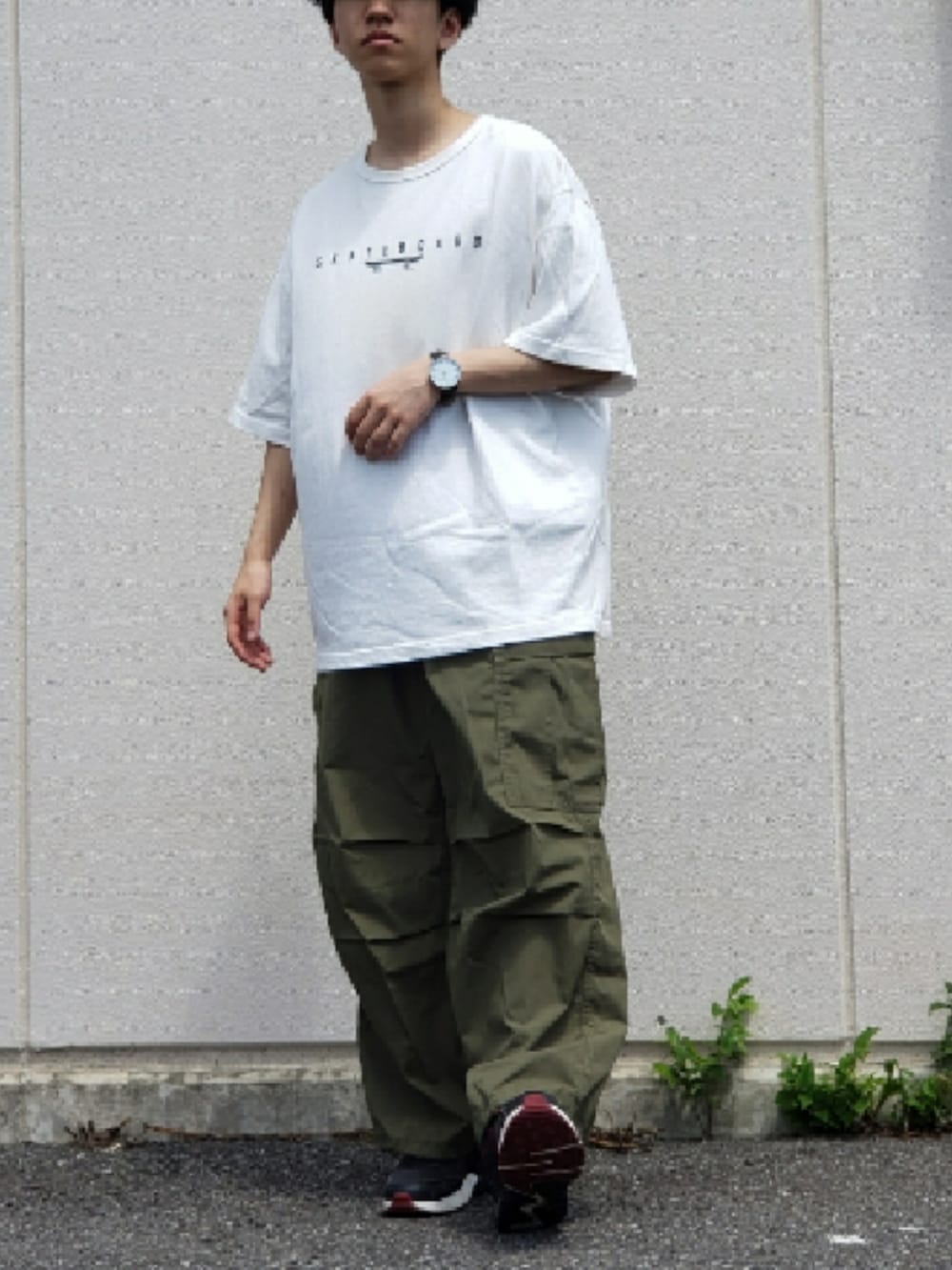 グリーン系のカーゴパンツ、ホワイト系のTシャツ/カットソー、ブラック系のスニーカーを着用したメンズの夏コーディネートの2枚目の写真