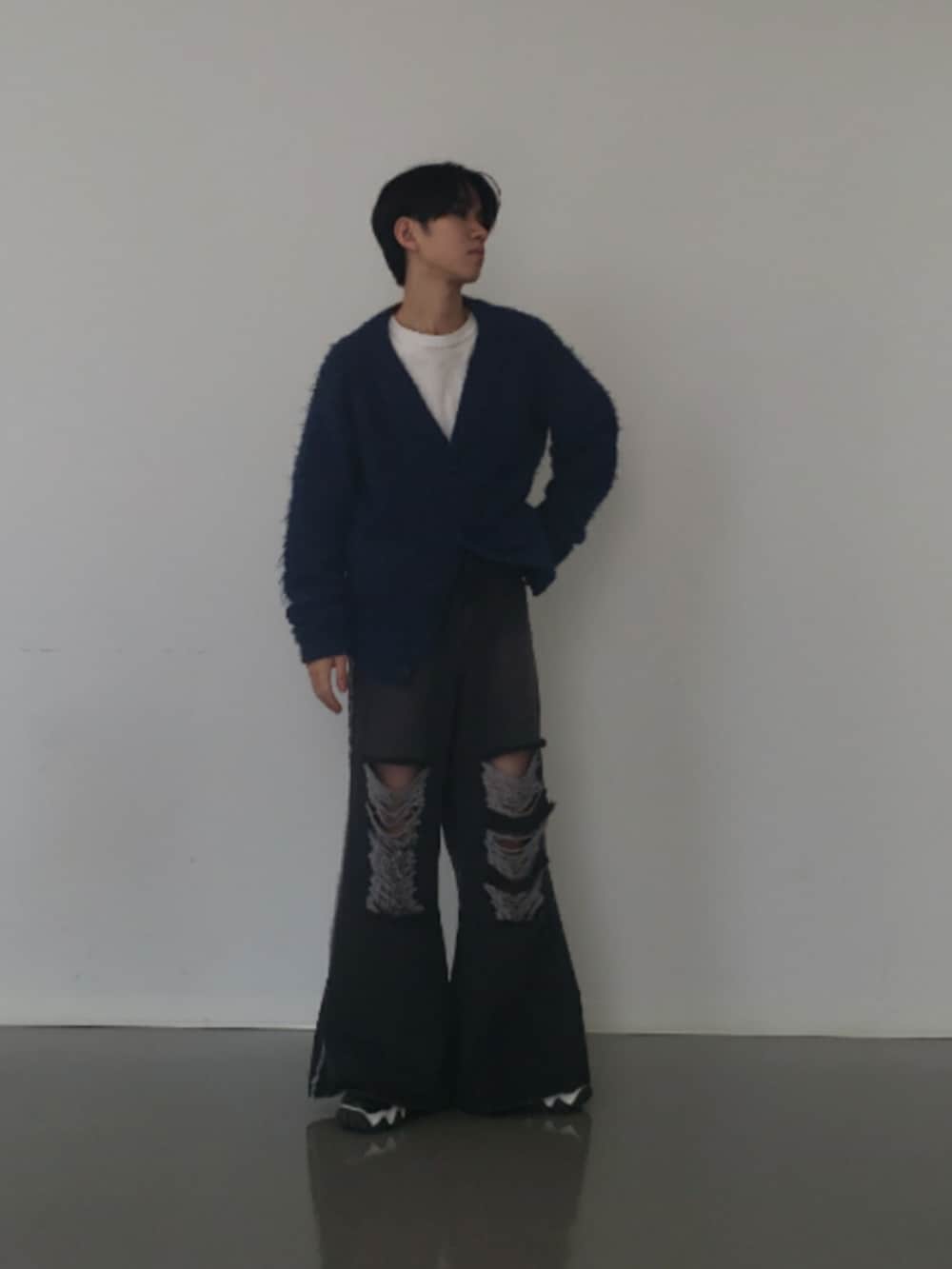 ブラック系のデニムパンツ、ブラック系のスニーカー、ブルー系のカーディガン/ボレロを着用したメンズの冬コーディネートの2枚目の写真