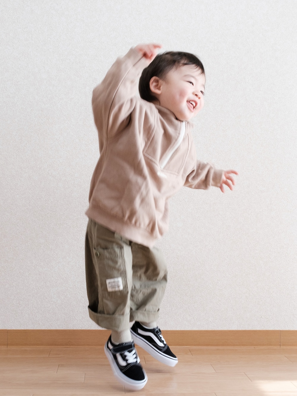 グリーン系のサロペット/オーバーオール、ブラック系のスニーカー、ベージュ系のスウェットを着用したキッズの春コーディネートの4枚目の写真