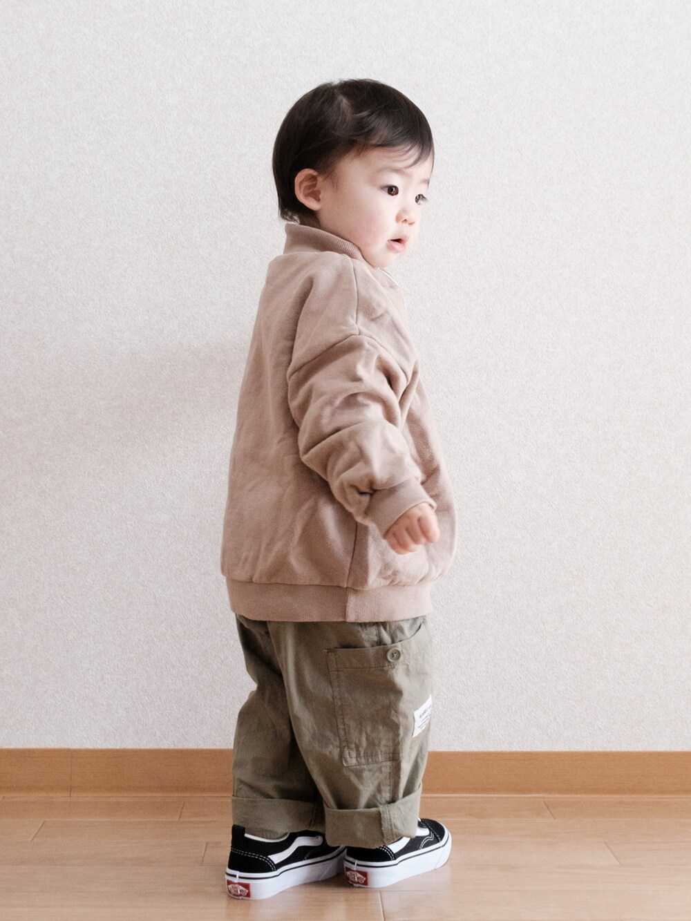 グリーン系のサロペット/オーバーオール、ブラック系のスニーカー、ベージュ系のスウェットを着用したキッズの春コーディネートの2枚目の写真