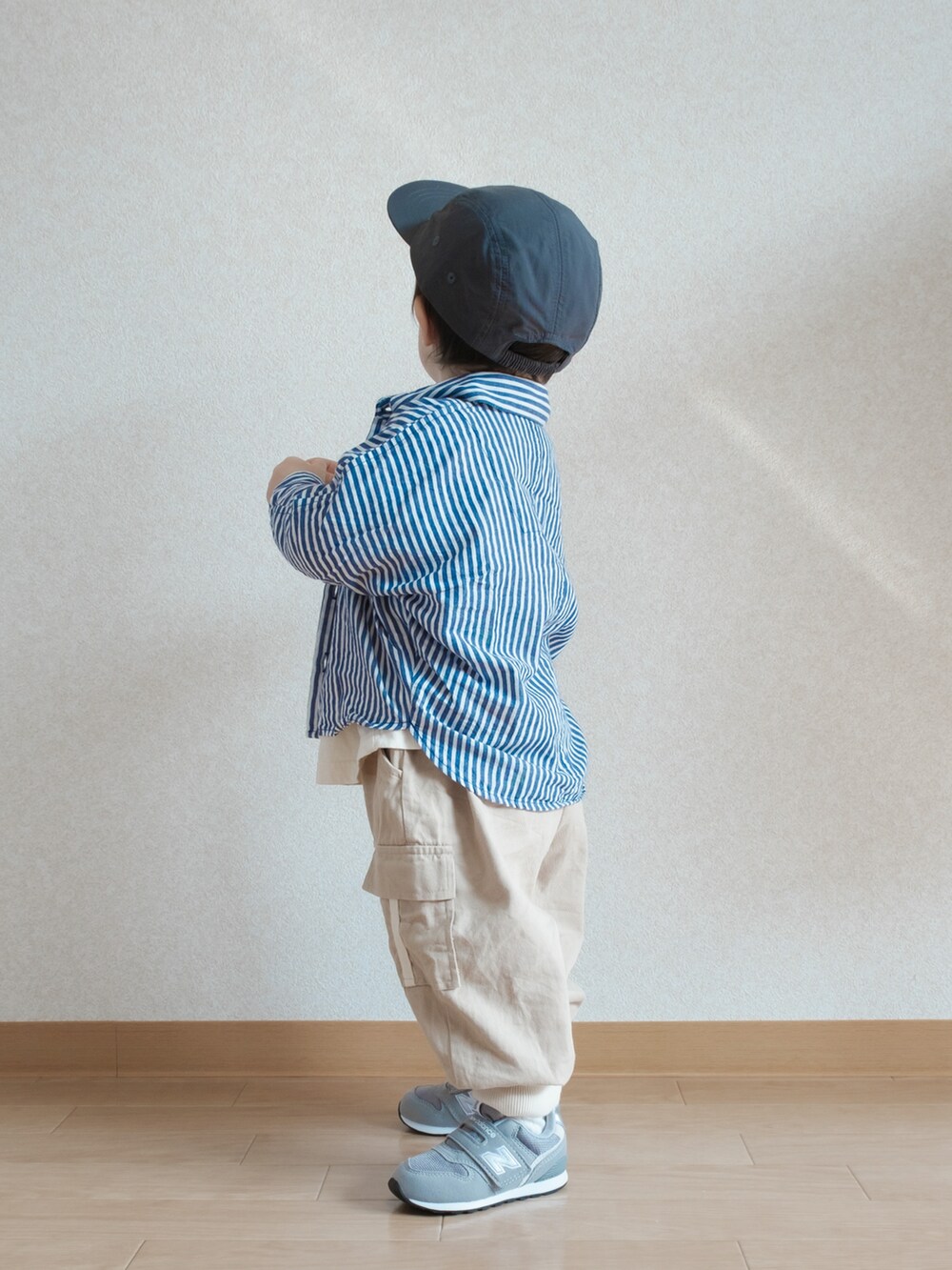 ブルー系のシャツ/ブラウス、グレー系のスニーカー、ブラック系のキャップを着用したキッズの春コーディネートの3枚目の写真