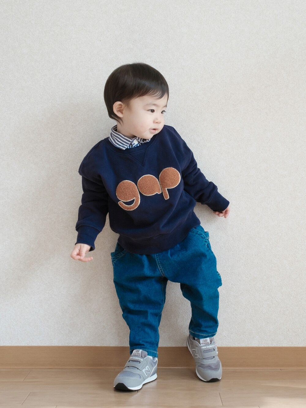 ブルー系のスウェット、ブルー系のデニムパンツ、グレー系のスニーカーを着用したキッズの春コーディネートの2枚目の写真