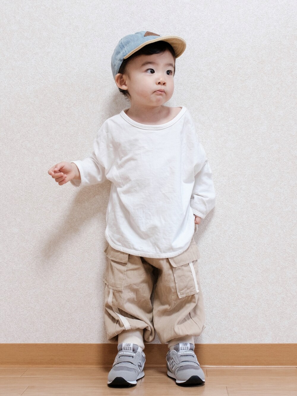 グレー系のスニーカー、ブルー系のキャップを着用したキッズの春コーディネートの2枚目の写真