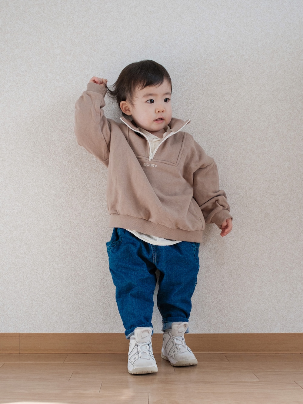 ベージュ系のスウェット、ブルー系のデニムパンツ、ホワイト系のスニーカーを着用したキッズの春コーディネートの2枚目の写真