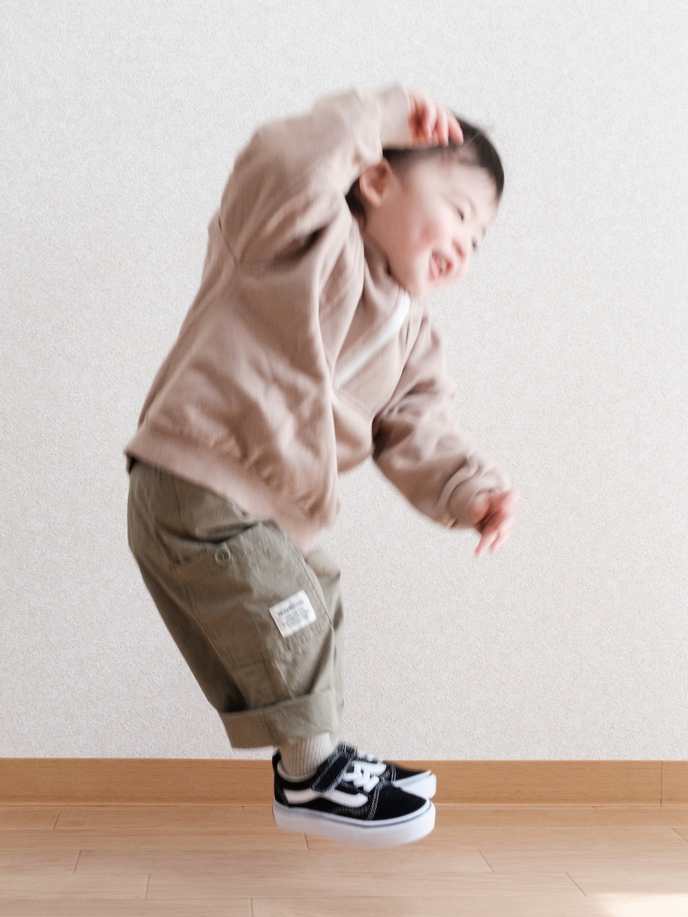 グリーン系のサロペット/オーバーオール、ブラック系のスニーカー、ベージュ系のスウェットを着用したキッズの春コーディネートの5枚目の写真