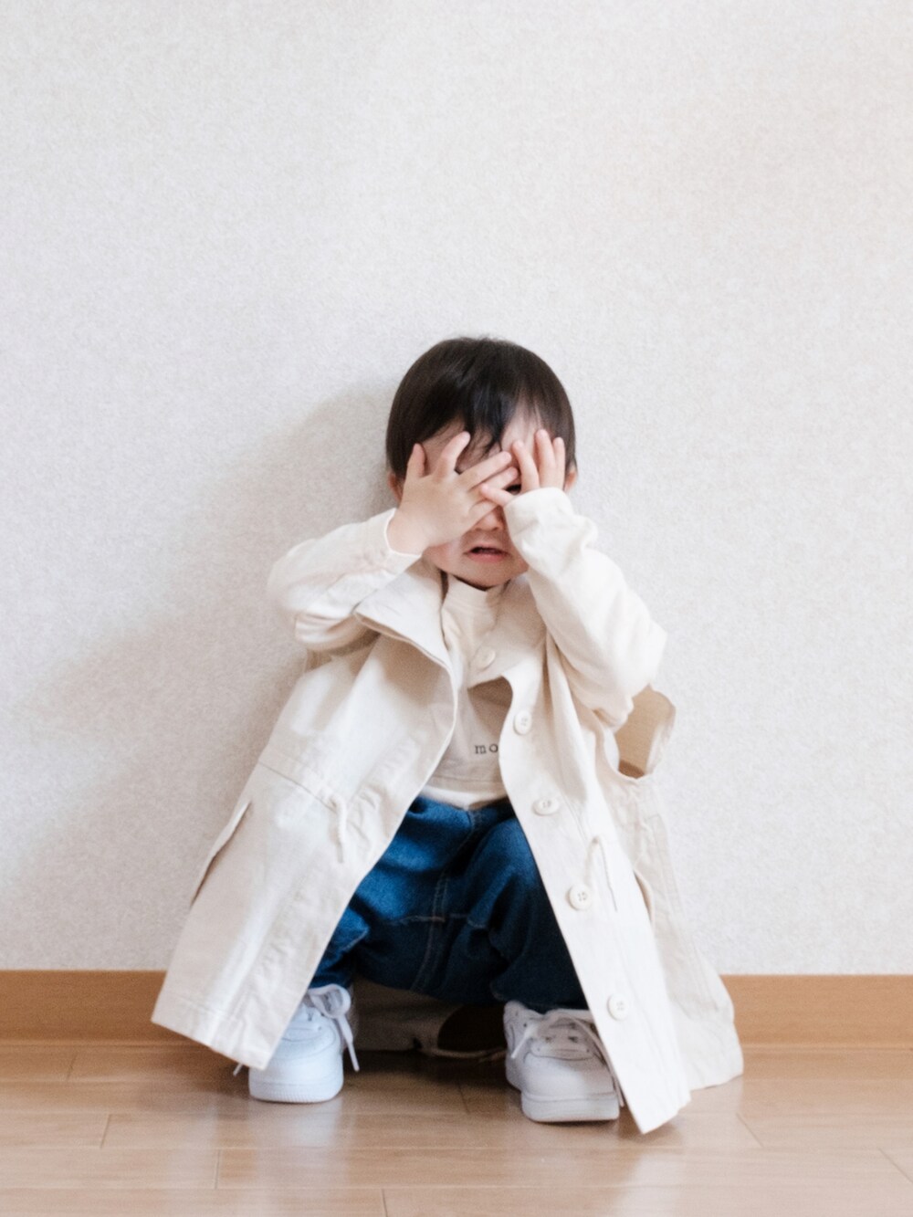 ブルー系のデニムパンツ、ホワイト系のベスト、ホワイト系のスニーカーを着用したキッズの春コーディネートの3枚目の写真