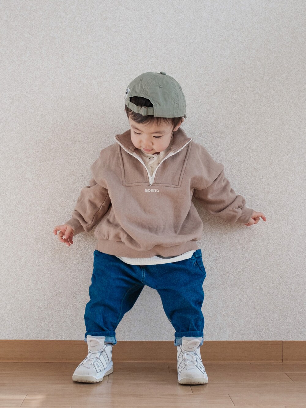 ベージュ系のスウェット、ブルー系のデニムパンツ、ホワイト系のスニーカーを着用したキッズの春コーディネートの4枚目の写真