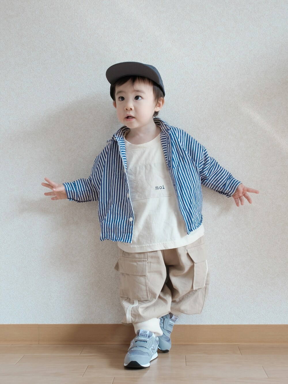 ブルー系のシャツ/ブラウス、グレー系のスニーカー、ブラック系のキャップを着用したキッズの春コーディネートの2枚目の写真