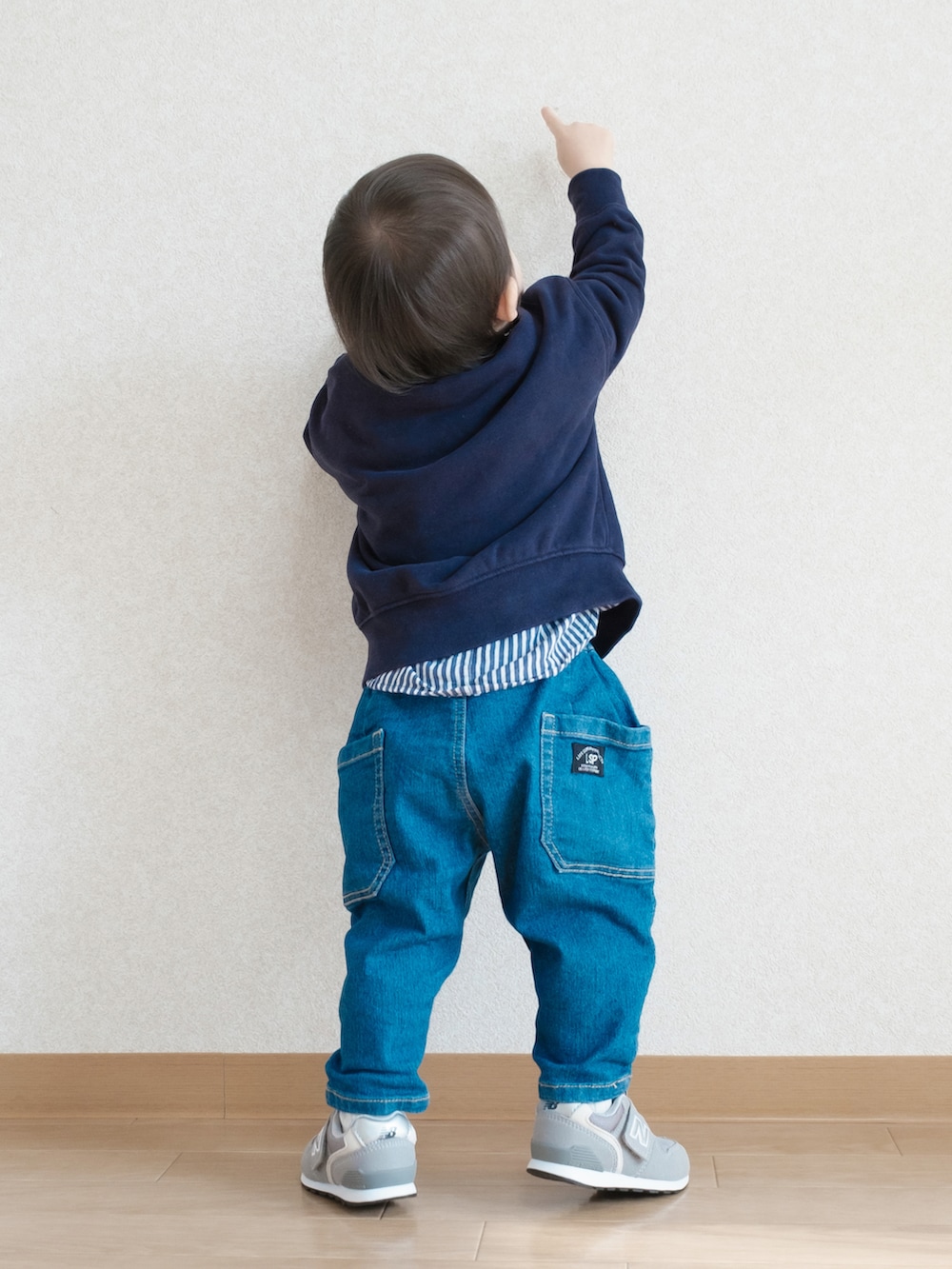 ブルー系のスウェット、ブルー系のデニムパンツ、グレー系のスニーカーを着用したキッズの春コーディネートの3枚目の写真