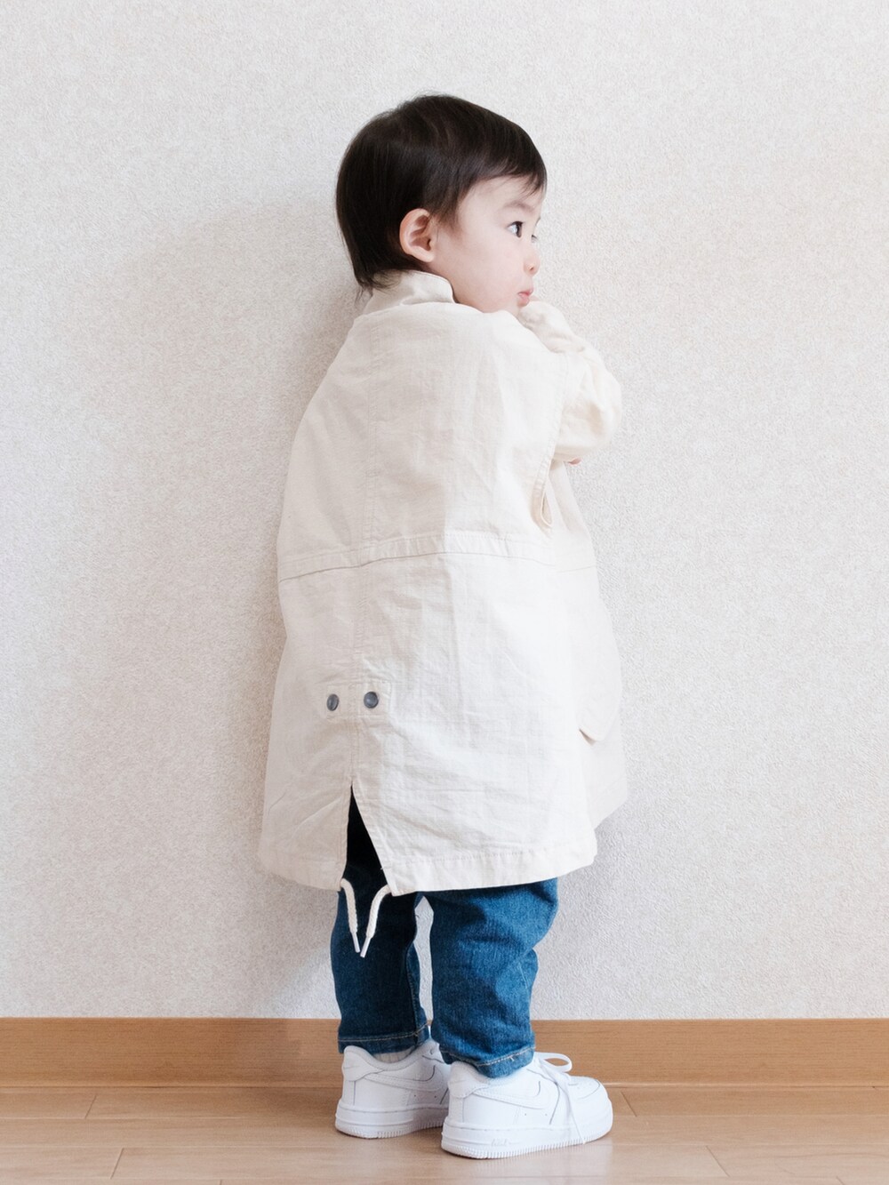 ブルー系のデニムパンツ、ホワイト系のベスト、ホワイト系のスニーカーを着用したキッズの春コーディネートの2枚目の写真