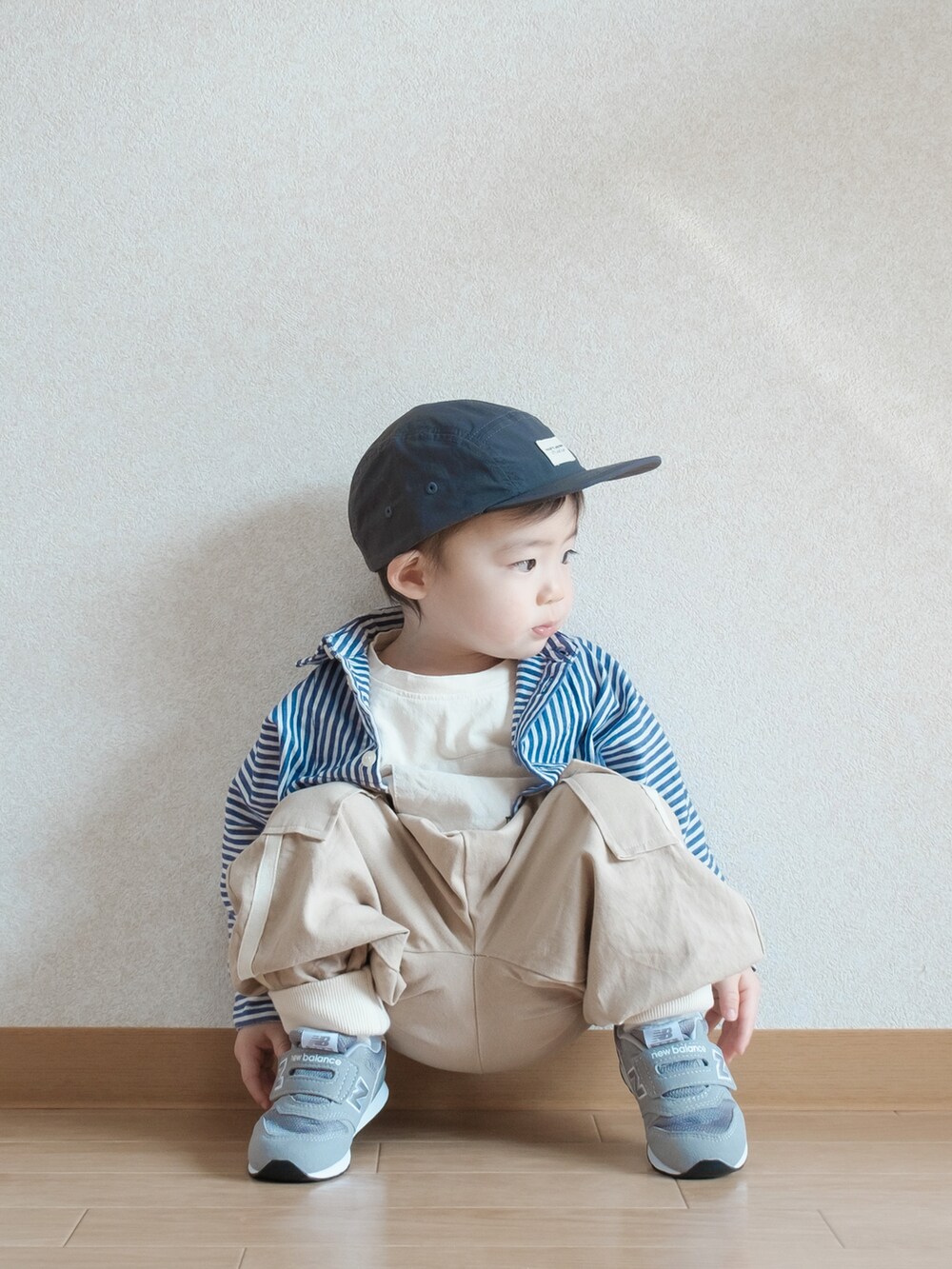 ブルー系のシャツ/ブラウス、グレー系のスニーカー、ブラック系のキャップを着用したキッズの春コーディネートの5枚目の写真
