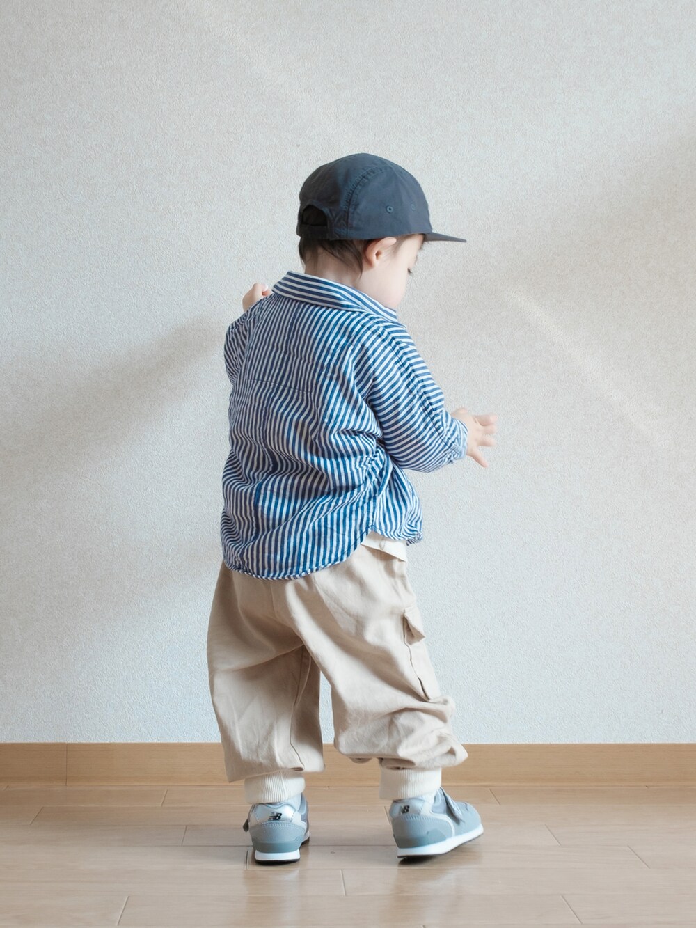 ブルー系のシャツ/ブラウス、グレー系のスニーカー、ブラック系のキャップを着用したキッズの春コーディネートの4枚目の写真