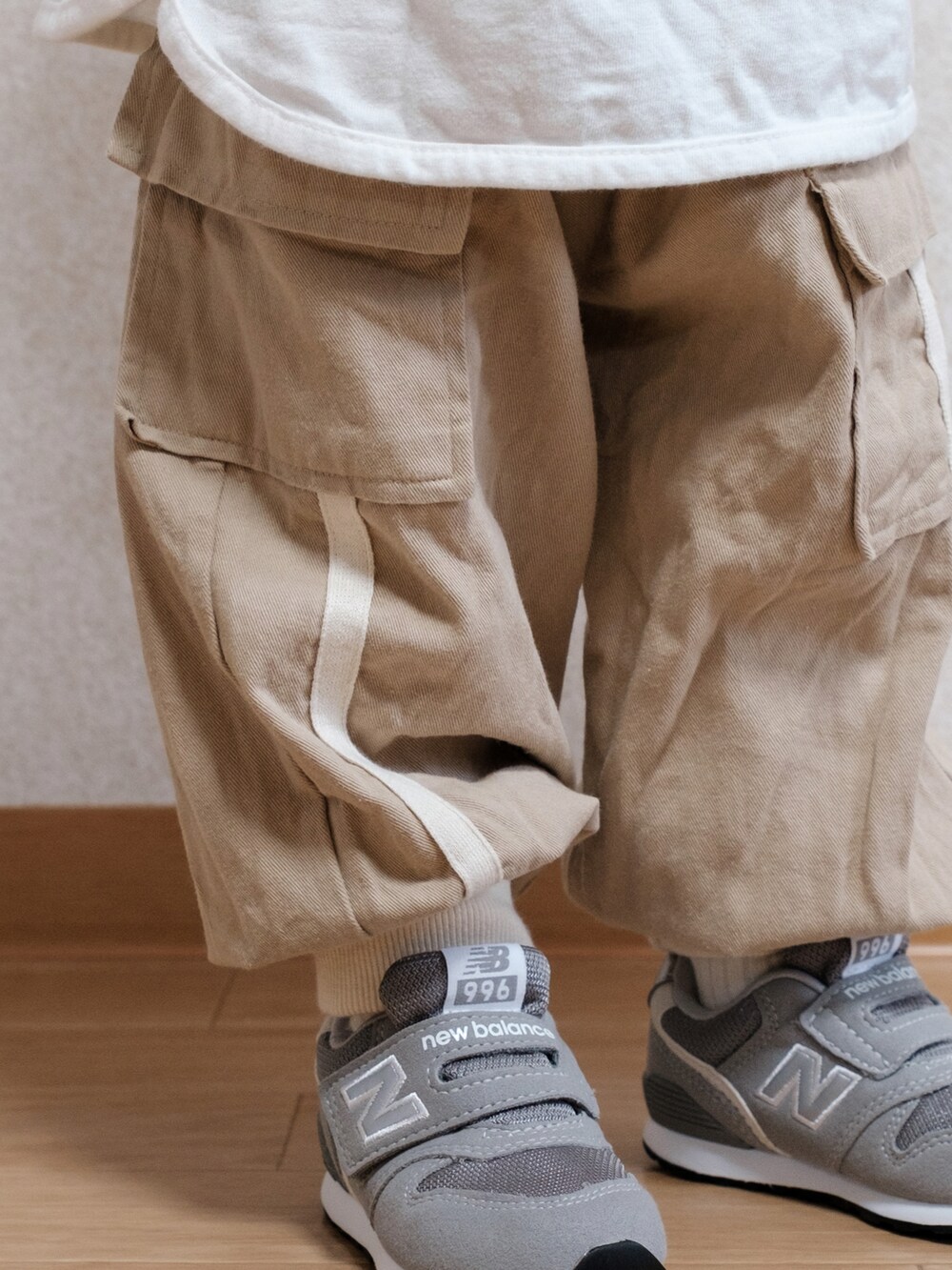 グレー系のスニーカー、ブルー系のキャップを着用したキッズの春コーディネートの3枚目の写真