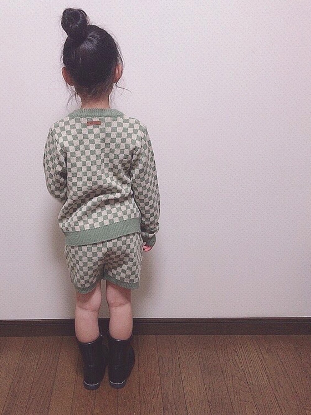 グリーン系のニット/セーター、ブラック系のブーツを着用したキッズの春コーディネートの4枚目の写真