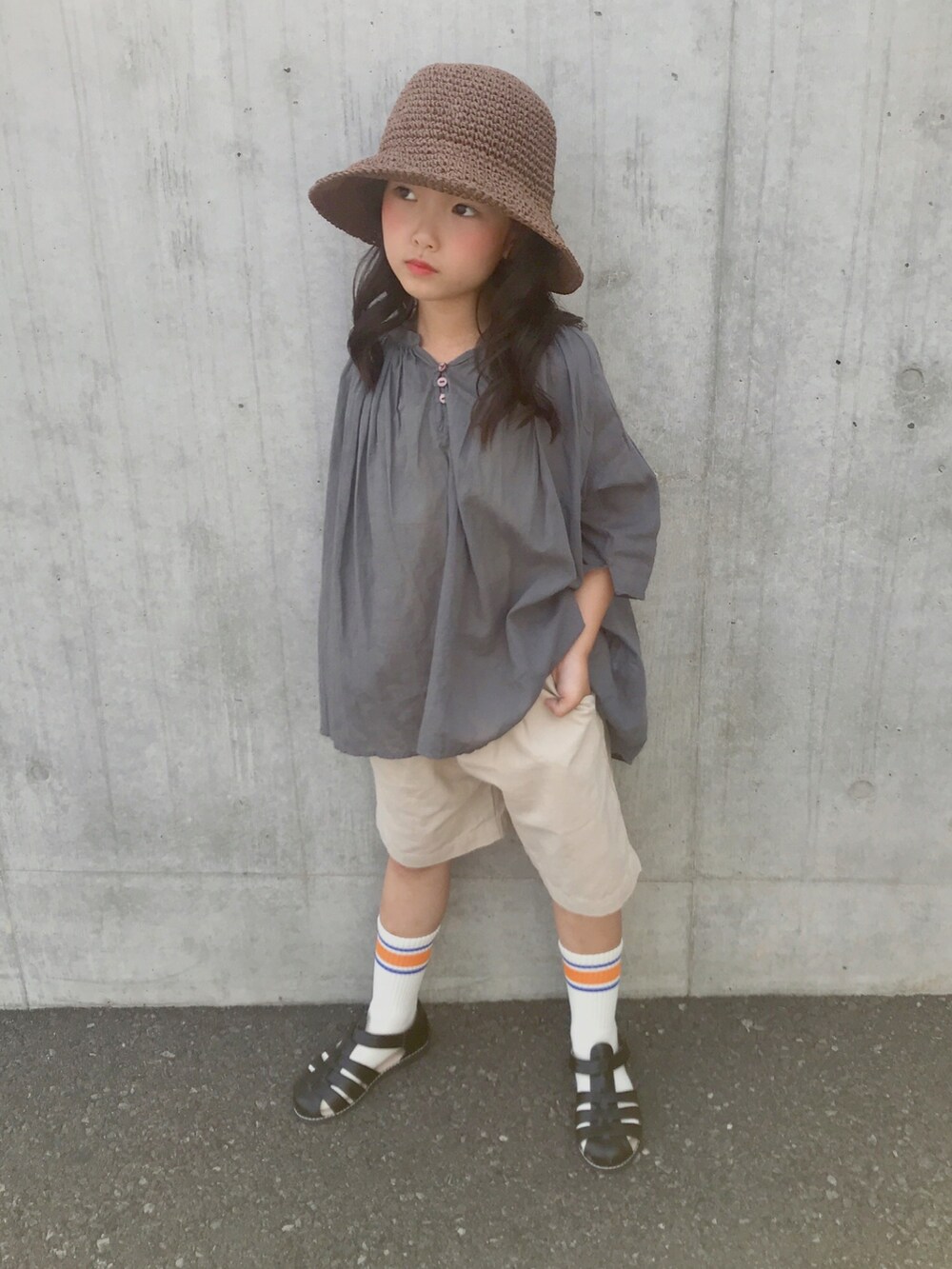 グリーン系のシャツ/ブラウス、ブラック系のサンダル、ブラウン系のハットを着用したキッズの夏コーディネートの2枚目の写真