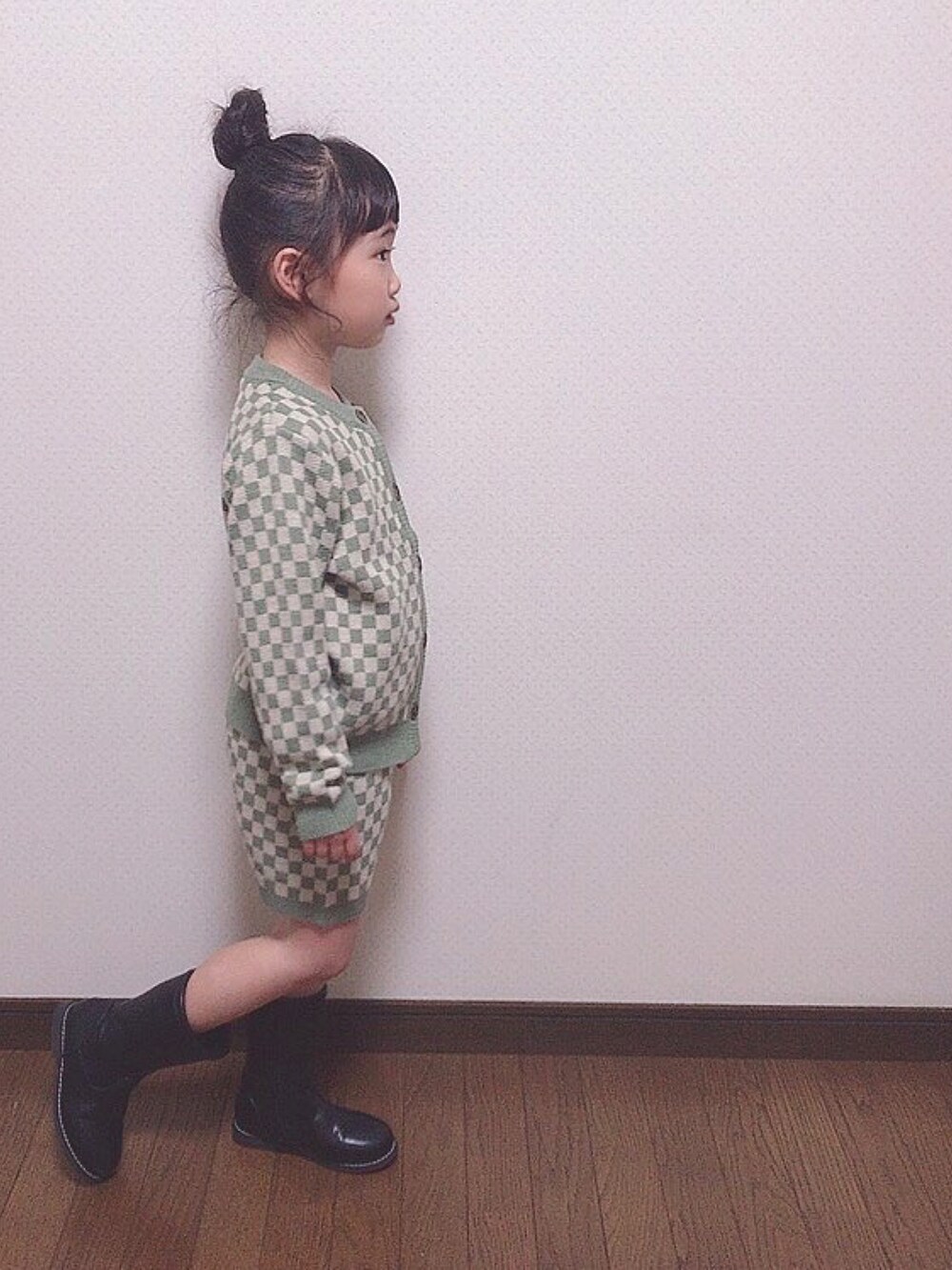 グリーン系のニット/セーター、ブラック系のブーツを着用したキッズの春コーディネートの3枚目の写真