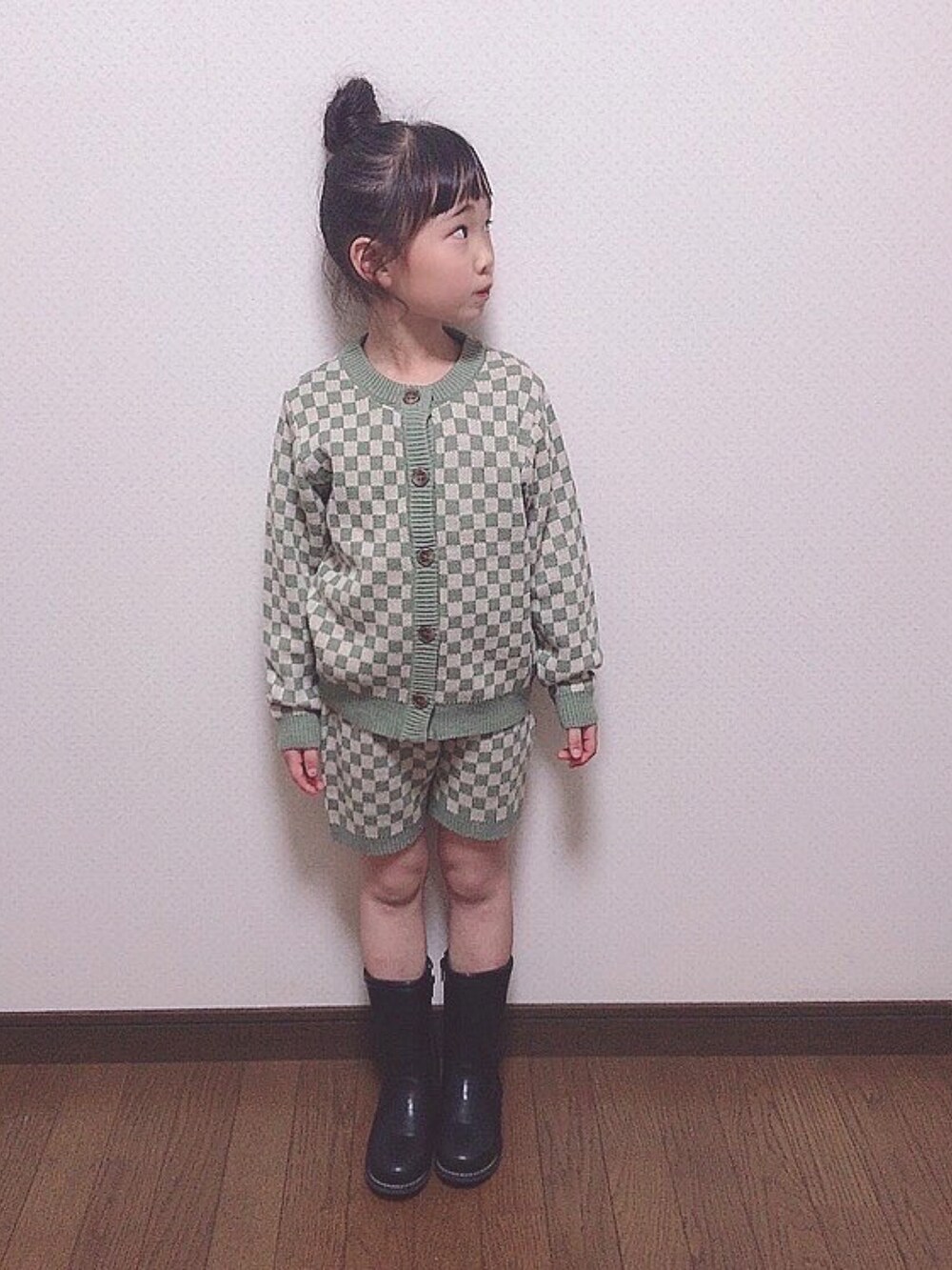 グリーン系のニット/セーター、ブラック系のブーツを着用したキッズの春コーディネートの2枚目の写真