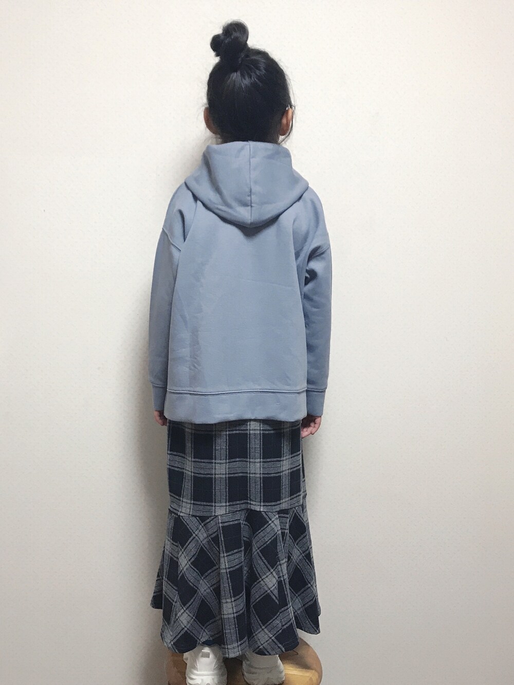 ブラウン系のショルダーバッグ、ブルー系のパーカー、ブラック系のスカートを着用したキッズの冬コーディネートの3枚目の写真